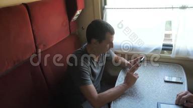 休闲男子从手机屏幕<strong>阅读</strong>，同时<strong>阅读</strong>短信旅行的火车生活方式车。 慢动作